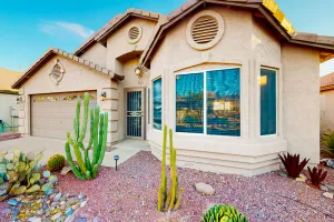 Image of Southwestern home with colorful patio, sparkling pool, grill & dart board