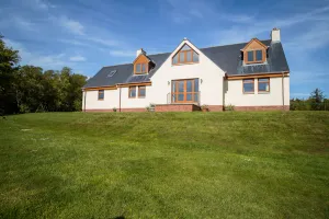 Image of Family house surrounded by lawn and woodlands with countryside views.