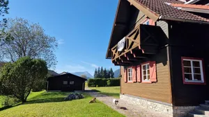 Image of cozy house in a sunny place with a fantastic mountain panorama