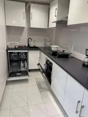 Image of L'appartement dispose d'un lit, d'un canapé-lit et d'une cuisine avec un réfrigérateur