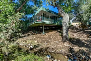 Image of Modern cabin hidden among the trees-- Unwind and relax on the porch creek-side.