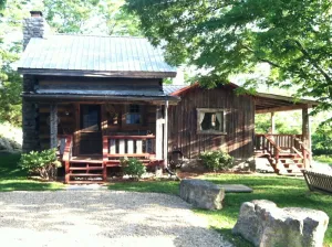 Image of 1800’s restored log cabin on 26 private rolling wooded acres with sunset views