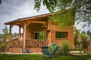 Image of Le colibri, wooden house near river and forest