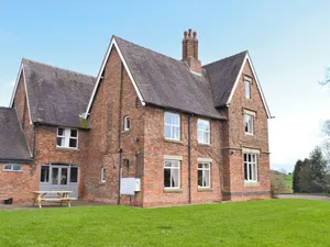 Image of An imposing farmhouse with eight bedrooms, a games room, large gardens and tennis courts.