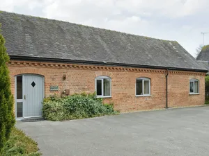 Image of One of two barn conversions with exposed beams and trusses.