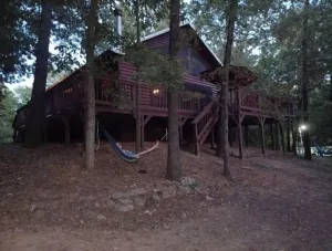 Image of 2 story log cabin with lake view. Located in front of Raymond Gary state park.