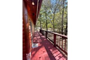 Image of 2 story log cabin with lake view. Located in front of Raymond Gary state park.