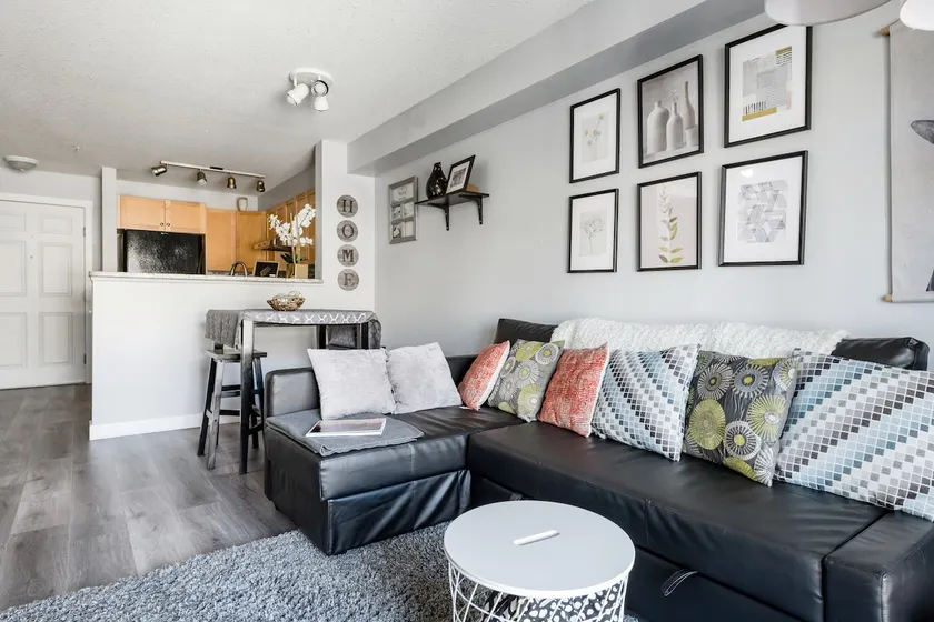Sink into the Sleek Leather Sectional at an Open-Concept Pad - Image 1