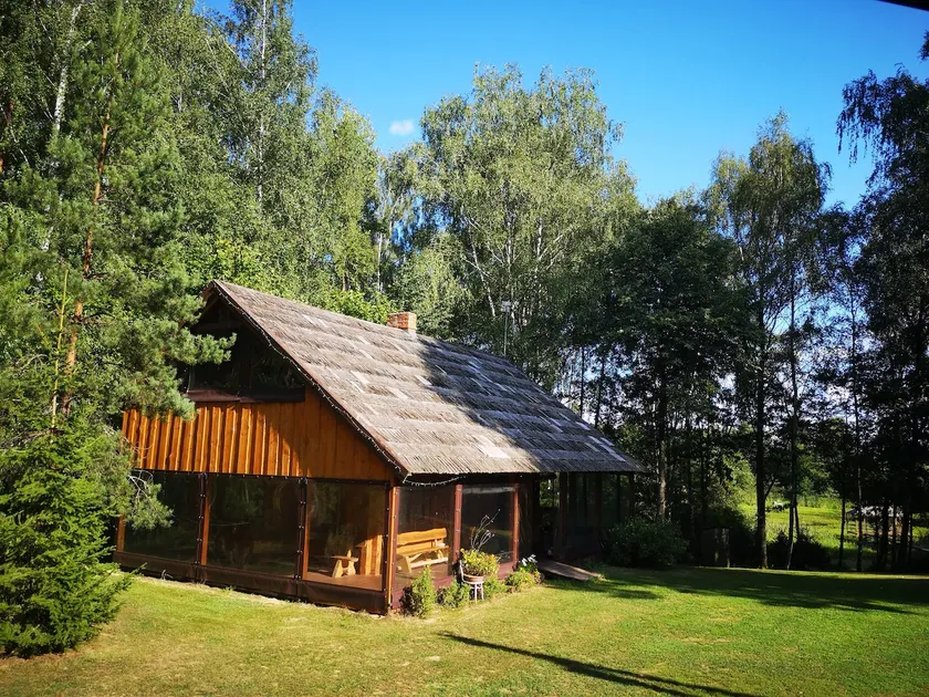Cabin house surrounded by deers and forest - Image 1