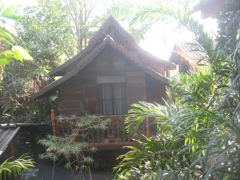 teak house in a topical garden - Image 1