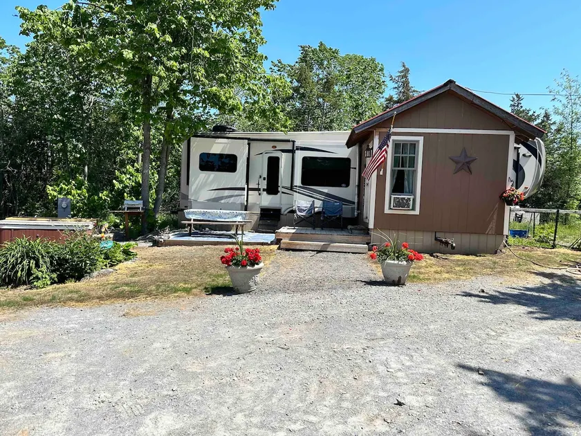 Rustic 5th wheel camper close to lake. - Image 1