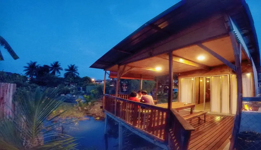 Tung's Tropika - with a wooden hut by a lake - Image 1