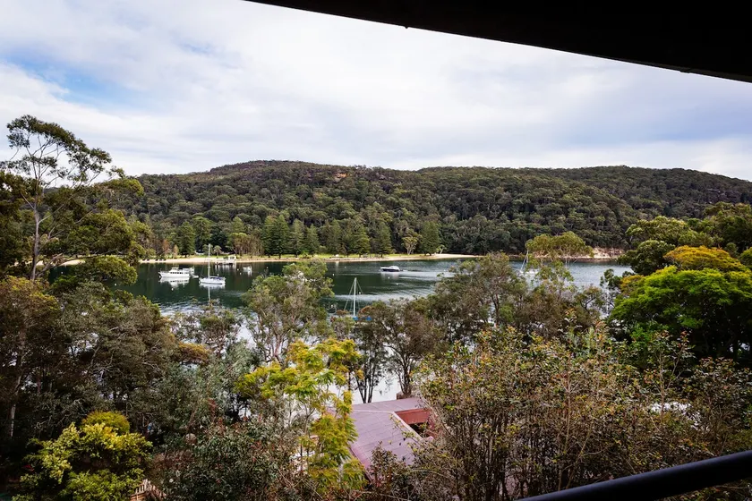 Water, trees, sky and a house on the rocks. - Image 1