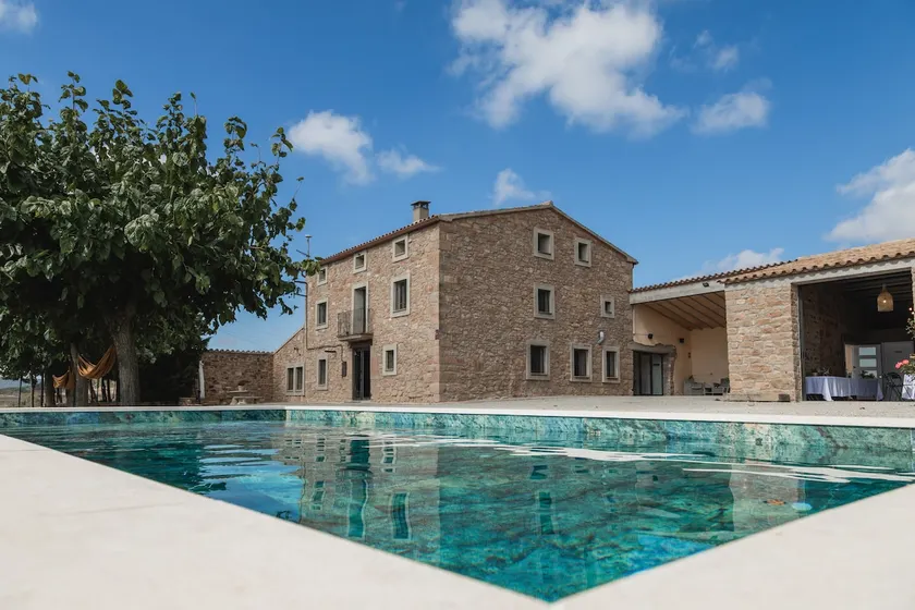 Stone farmhouse with pool, surrounded by fields. - Image 1