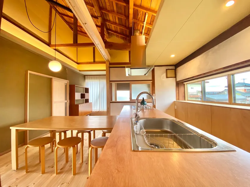 A house with a large veranda, tatami room, and open kitchen with a ceiling fan. The kitchen and bathroom are equipped with the latest facilities. - Image 1