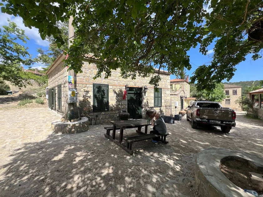 Stone house with a historical courtyard in Adatepe village square - Image 1