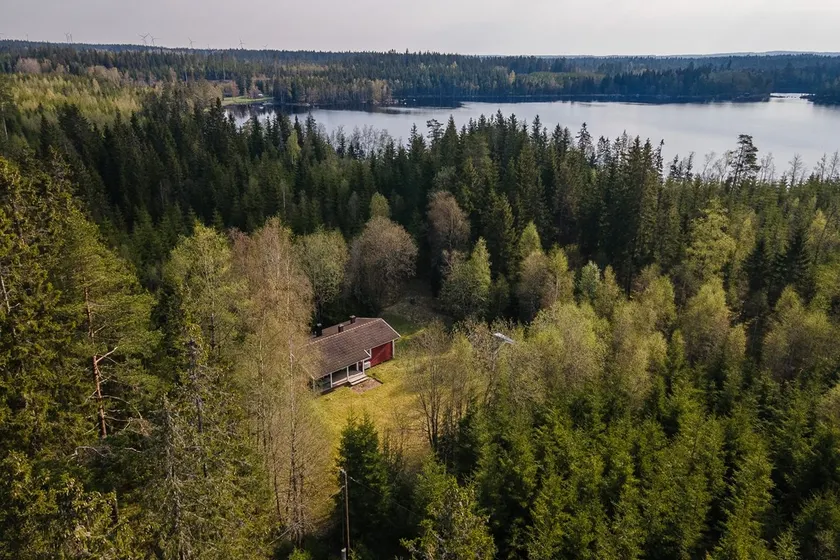 Cabin with a unique location in the forest by a lake. - Image 1