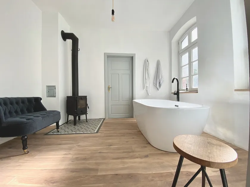 A bathtub next to the fireplace, close to a lake - Image 1
