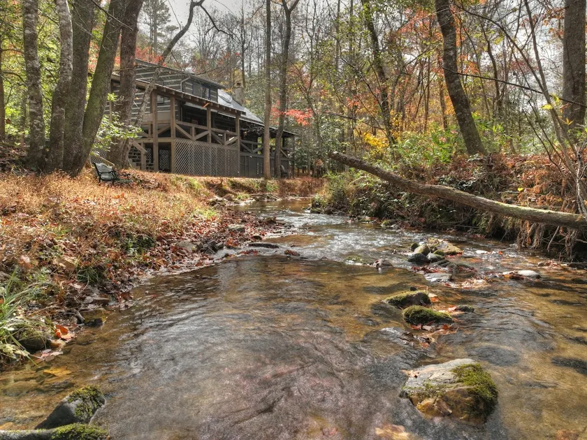 Indulge in "Just One More Night", a pet-friendly creekfront retreat boasting a spacious outdoor deck, hot tub, firepit, and WiFi - Image 1