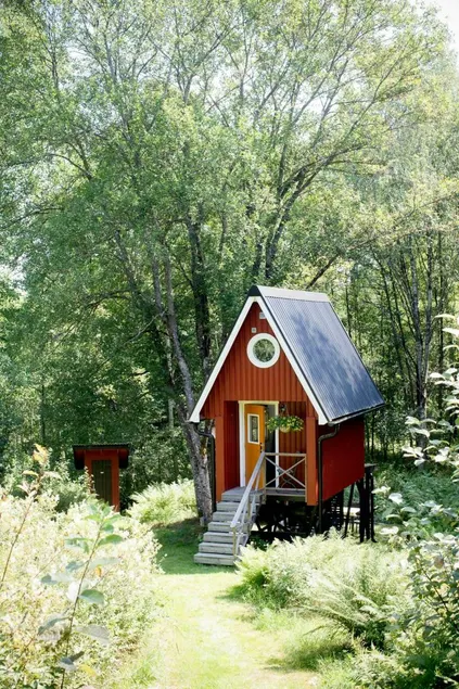 Small cabin with outdoor kitchen by forest stream - Image 1