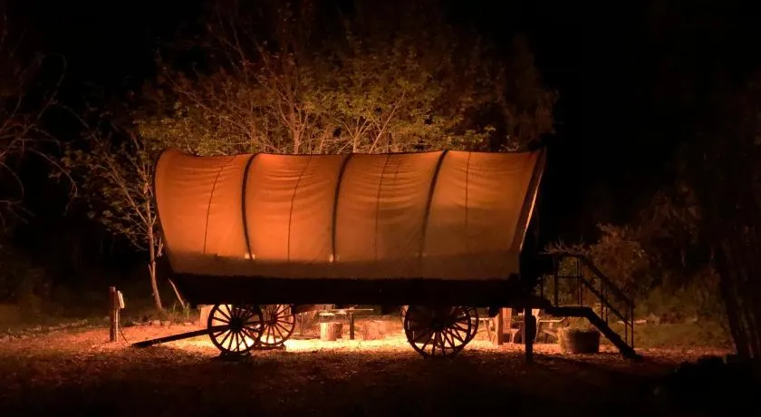 Cozy Wild West Covered Wagon next to River - Image 1