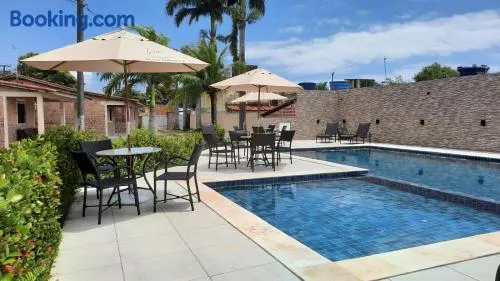 CASA no FORTE com 80 m2, 2 quartos com ar condicionado, cozinha completa, acomoda 8 pessoas, campinho, parquinho infantil, piscinas, área de lazer, estacionamento para 2 carros, WIFI, câmeras de segurança, portaria, ambiente familiar. - Image 1