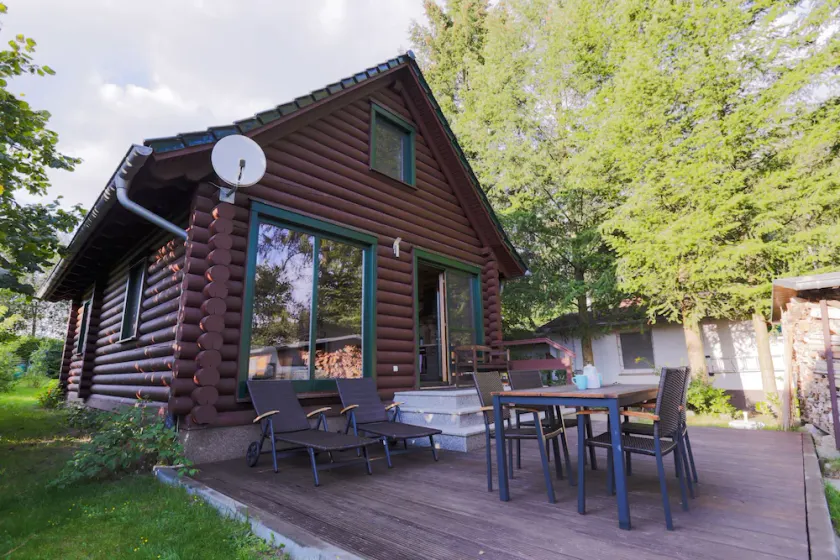 Cabane en rondins sur le lac avec cheminée, jardin, terrasse, bateau, et beaucoup de nature - Image 1