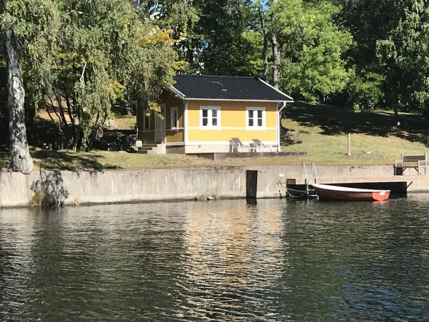 Cottage with sunny wooden deck by water. Rowing boat included. - Image 1