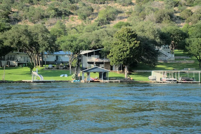 Lakefront retreat on quiet cove with large deck and sweeping views. - Image 1