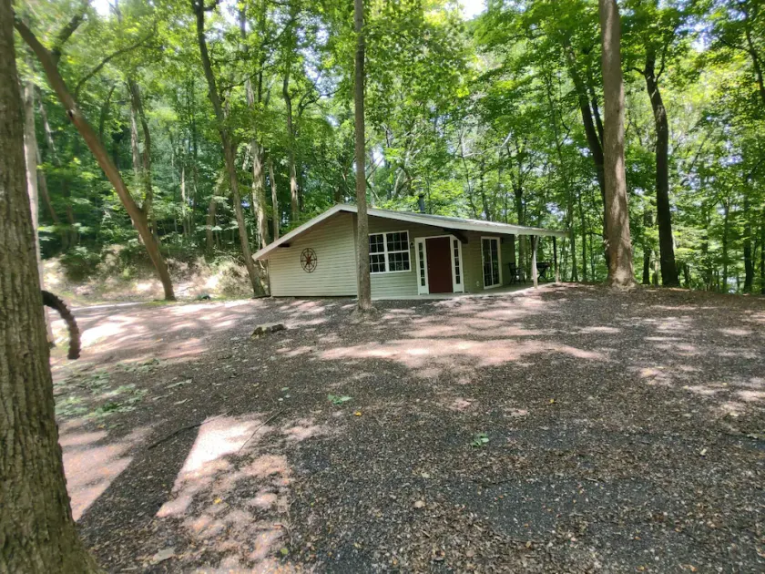 The Chalet is located in the woods of a gated property with a covered porch. - Image 1