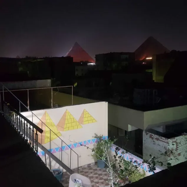 It's a house .it has aquit roof  with a view  of pyramids - Image 1