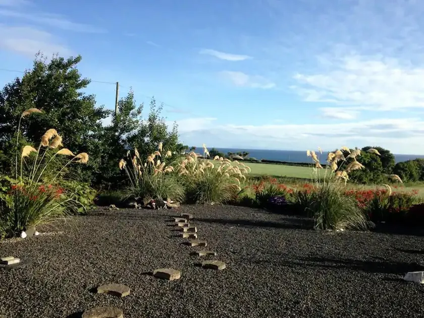 Encantadora casa vacacional apta para niños con jardín | Vistas a la playa - Image 1