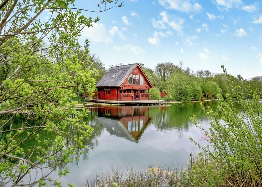 Set in a peaceful location and perched over the lake. - Image 1