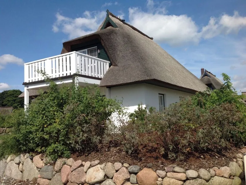 The thatched-roof house \"Binsenkate\" in Zinnowitz. Balcony with a magnificent view of the Achterwasser. Sunny garden with a patio, lounge chairs, and a Weber electric grill. Child-friendly amenities - Image 1
