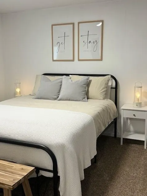Completely Renovated home comfortably accommodates your stay with a queen bed in the primary bedroom, a twin bed with a pull-out trundle in the second bedroom, and a sleeper sofa in the living room for additional guests. - Image 1
