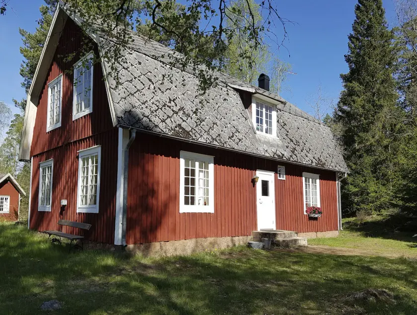 Typical red and white holiday home surrounded by forest and lake - Image 1