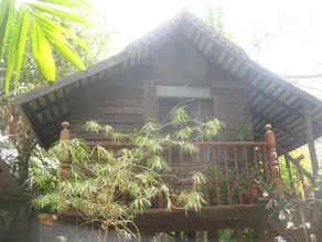 teak house in a topical garden - Image 5