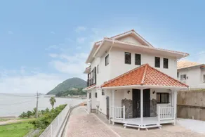 OCEAN STAY HAKUTO: A building with a tiled roof and a vibrant orange color against the backdrop of the ocean and sky will welcome you - Image 2