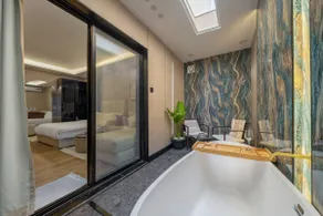 Luxury hotel suite with bathtub and sitting area - Image 4