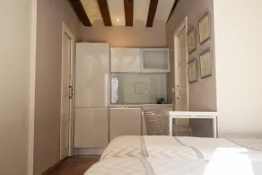 A room with a kitchen. - Image 4