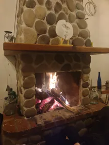 House surrounded by nature and a fireplace inside - Image 4