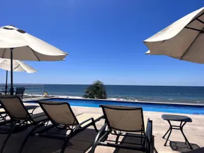 A beachfront property with a view of the marina and a heated pool - Image 4
