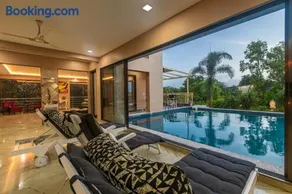 SaffronStays Aura - 4BR luxury pool villa with gym, BBQ deck, lawns & indoor games near Kihim Beach - Image 1