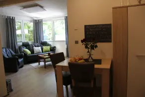 Modernly furnished bungalow with fireplace, surrounded by greenery. - Image 5