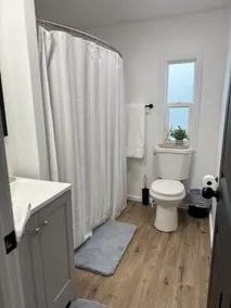 Completely Renovated home comfortably accommodates your stay with a queen bed in the primary bedroom, a twin bed with a pull-out trundle in the second bedroom, and a sleeper sofa in the living room for additional guests. - Image 3