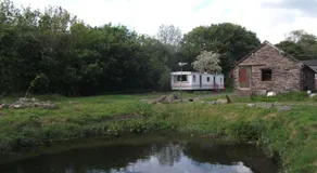 caravan nestled away amongst trees on edge of farm yard - Image 4